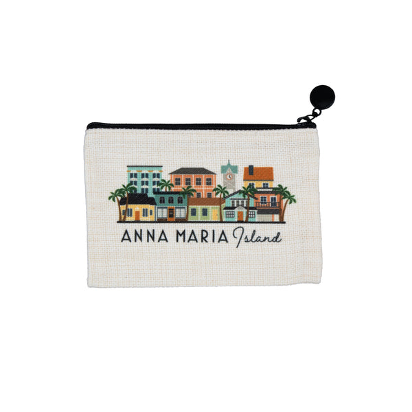 A small zippered pouch on a white background, featuring a colorful illustration of 'Anna Maria Island' buildings and palm trees on a cream-colored woven fabric.