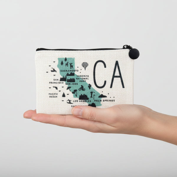 A square canvas pouch with a black zipper and black pom-pom pull, featuring a printed map of California with the large letters 'CA' in black.