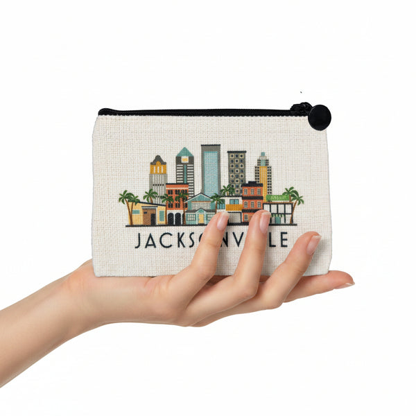 A cream-colored canvas zippered pouch featuring a colorful embroidered Jacksonville skyline and the text 'JACKSONVILLE' in black, with a black zipper and pull tab.