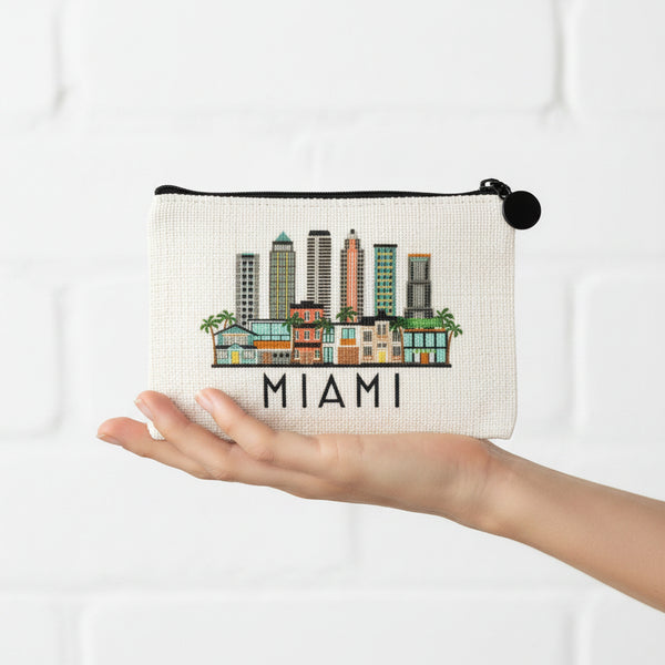 An off-white canvas zippered pouch featuring a colorful Miami skyline illustration and the word 'MIAMI' printed in black below it, shown against a plain white background.