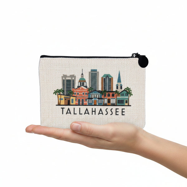 An off-white canvas zippered pouch featuring a colorful printed skyline of Tallahassee, with the city name printed in black below the illustration.