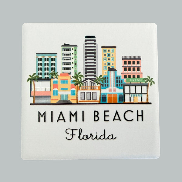 Decorative square with colorful illustration of Miami Beach buildings and text on a gray background