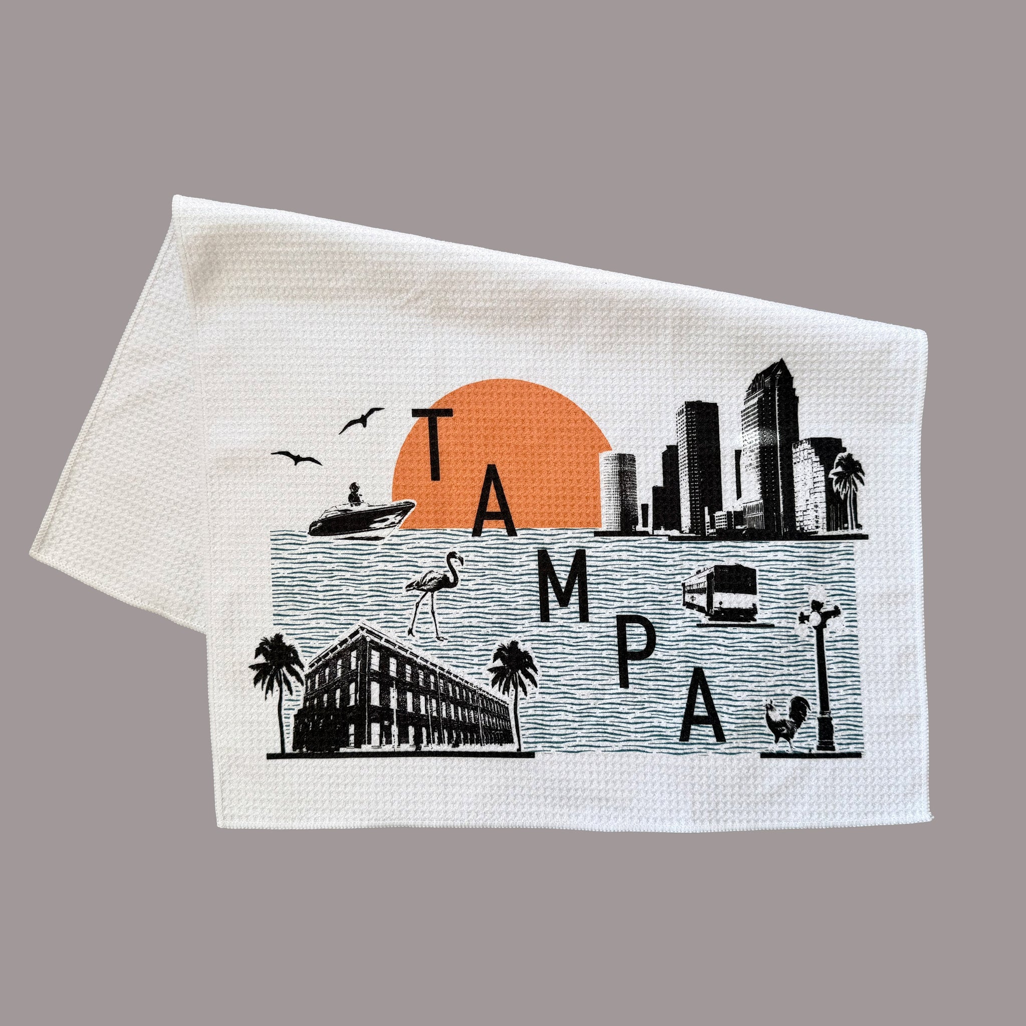 Towel with a graphic of Tampa skyline and sunset on a gray background