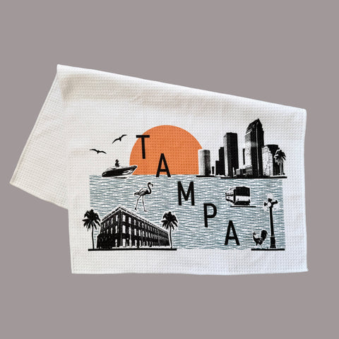 Towel with a graphic of Tampa skyline and sunset on a gray background
